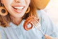 Asian woman in hat eating delicious grilled octopus in seafood restaurant. Delicacy and healthy gourmet cuisine