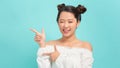 Happy asian woman having idea and winks at the camera over blue background