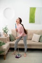 Happy asian woman in headphones with mop and bucket cleaning floor and singing at home Royalty Free Stock Photo