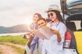 Happy Asian woman and her friends standing by car. Young girl having fun during road trip. People lifestyles and travel vacation Royalty Free Stock Photo