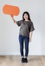 Happy Asian woman holding copyspace speech bubble Royalty Free Stock Photo