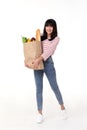 Happy Asian woman holding paper bag full of fresh vegetable groceries isolated on white background Royalty Free Stock Photo