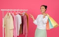 Asian Woman Holding Shopping Bags And Pointing At Rack With Trendy Clothes Royalty Free Stock Photo