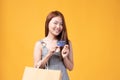 Happy Asian woman holding shopping bags and showing credit card. Beautiful charming woman with many shopping bags brand name Royalty Free Stock Photo