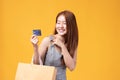 Happy Asian woman holding shopping bags and showing credit card. Beautiful charming woman with many shopping bags brand name Royalty Free Stock Photo