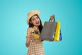 Happy Asian woman holding shopping bags and showing credit card isolated on blue background Royalty Free Stock Photo
