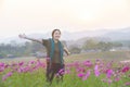 Happy asian woman lady standing on cosmos flower field rise hand up with happy and freedom face process picture in vintage style Royalty Free Stock Photo