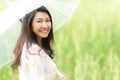 Happy asian woman lifestyle hand holding umbrella in the meadow yellow flower sunrise.