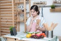 Happy asian woman looking recipe tablet kitchen reading cooking at home,University colleague student study online with social Royalty Free Stock Photo