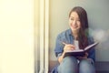 Happy Asian woman with notebook and pen