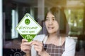 Happy asian woman owner turning open sign after lockdown quarantine in modern cafe Royalty Free Stock Photo