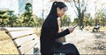 Happy asian woman, phone and typing on park bench for social media, communication or networking. Female person smile in Royalty Free Stock Photo