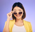 Happy asian woman, portrait and sunglasses for fashion or stylish accessory against a purple studio background. Female Royalty Free Stock Photo