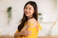 Happy Asian Woman received anti virus vaccine cheerful thumbs up with bandage,young woman enjoying and confident with future