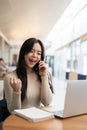 A happy Asian woman rejoicing after receiving good news over the phone Royalty Free Stock Photo