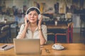 Happy Asian woman relaxing and listening music in coffee shop wi Royalty Free Stock Photo