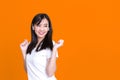 Happy Asian woman 20s listening to music via wireless earphones smiling and dancing isolated over background Royalty Free Stock Photo