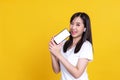 Happy Asian woman 20s singing while holding smartphone like microphone and listening to music via earphones isolated over backgrou Royalty Free Stock Photo