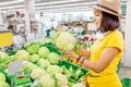 Asian Woman shopping for vegetables and looking at cauliflower cabbage in supermarket, healthy food concept Royalty Free Stock Photo