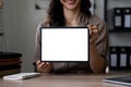 Happy asian woman showing tablet computer with blank screen while sitting at office, mockup for advertising. Royalty Free Stock Photo