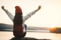 Happy Asian woman sitting on rock in nature during sunset