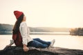 Happy Asian woman sitting on rock in nature during sunset