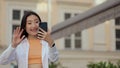 Happy asian woman speaking on video call in street. Smiling woman making video call on mobile phone in city walk. Girl Royalty Free Stock Photo