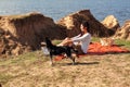 Happy asian woman at sunset, relaxing with her dog on the hills. Royalty Free Stock Photo