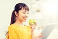 Happy asian woman with tablet pc and apple at home Royalty Free Stock Photo