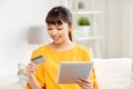 Happy asian woman with tablet pc and credit card Royalty Free Stock Photo