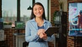 Happy asian woman taking notes on clipboard files in creative agency office