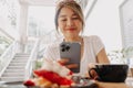 Happy woman taking photo of her cake in the cafe before eat. Royalty Free Stock Photo