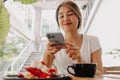 Happy woman taking photo of her cake in the cafe before eat. Royalty Free Stock Photo