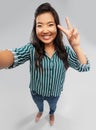 Happy asian woman taking selfie and showing peace Royalty Free Stock Photo