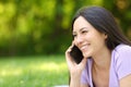 Happy asian woman talking on phone in a green park Royalty Free Stock Photo