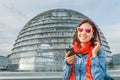 Happy asian woman traveler listen to audioguide in Berlin Reichstag roof at the famous glass dome, Royalty Free Stock Photo