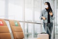 Woman traveler wearing mask holding smartphone