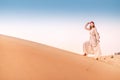 Asian woman in turban travels in Sahara desert. Adventure and life experience concept Royalty Free Stock Photo