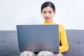 Happy asian woman using laptop while sitting on sofa in living room, WFH work from home concept Royalty Free Stock Photo