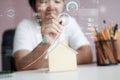 Happy Asian woman using pencil draw and plan with wooden house piggy bank and Cyber technology HUD GUI user interface metaphor Royalty Free Stock Photo