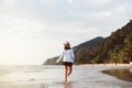 Happy asian woman walking on the beach near sea while beautiful sunset time,Relaxing and enjoying concept Royalty Free Stock Photo