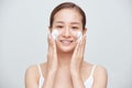 Happy Asian woman wash her face with soap foam over white background Royalty Free Stock Photo