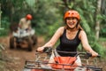 happy asian woman wearing savety helmet while riding atv through the track Royalty Free Stock Photo