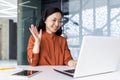 Happy Asian woman working inside office, businesswoman with video call headset talking and advising customers remotely Royalty Free Stock Photo