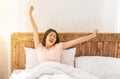 Happy asian woman yawning waking up in bed at home Royalty Free Stock Photo