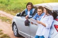 Happy Asian woman and her friends standing by car on coastal road at sunset. Young girl having fun during road trip. People Royalty Free Stock Photo