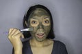 Happy Asian women smiling when she use brush to beauty face mask Royalty Free Stock Photo