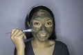 Happy Asian women smiling when she use brush to beauty face mask Royalty Free Stock Photo