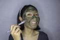 Happy Asian women smiling when she use brush to beauty face mask Royalty Free Stock Photo