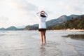 Happy asian woman walking on the beach near sea while beautiful sunrise time,Relaxing and enjoying concept Royalty Free Stock Photo